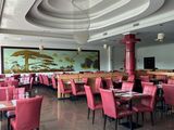 des tables et des chaises dans un restaurant où est accroché un grand tableau au mur