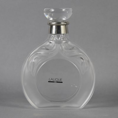 a close up of a bottle of perfume on a gray surface