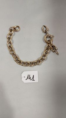 Gros plan sur un bracelet en or portant une étiquette