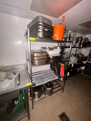 de nombreuses casseroles et poêles sur les étagères de la cuisine