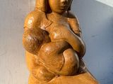 une statue représentant une femme tenant un bébé dans ses bras, posée sur une étagère