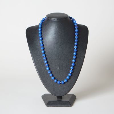 un collier de perles bleues sur un mannequin noir