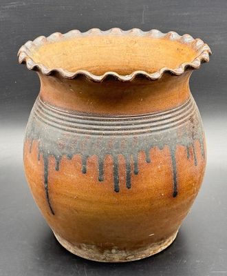 a brown and black vase sitting on a table