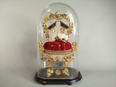 a glass clochet with a red cushion underneath it