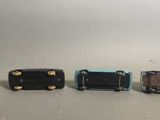 three miniature cars that are lined up on a table