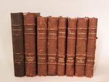 plusieurs vieux livres sont alignés sur une surface blanche