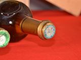 a bottle of wine sitting on a red table cloth