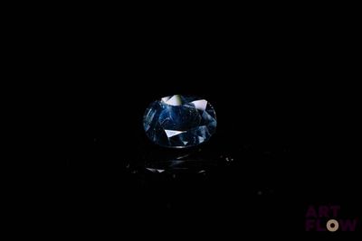 gros plan d'un diamant bleu sur une surface noire