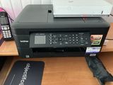 une imprimante posée sur un bureau à côté d'un téléphone portable