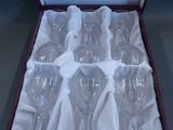 six empty wine glasses in a box on a table