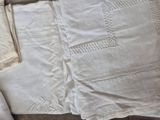 a pair of white linens and a pair of white linens on a table