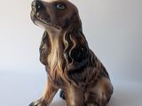 brown and black dog figurine sitting on a white surface