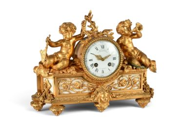 une horloge dorée ornée d'anges sur fond blanc