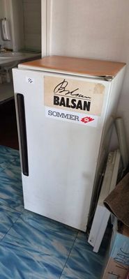 un petit réfrigérateur blanc posé dans un coin de la cuisine