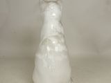 a white cat figurine sitting on a table