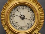 a gold clock that is hanging on the wall