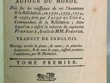 un vieux livre posé sur une table à côté d'une tasse de café