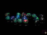 several different colored glass beads sitting on top of a black surface