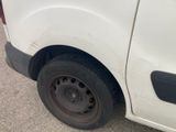 a white van with a flat tire parked in a parking lot