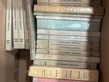 many books in a box that are stacked together