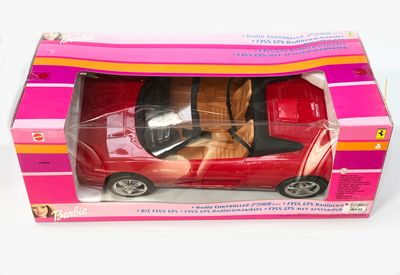 une petite voiture rouge dans une boîte rose posée sur une surface blanche
