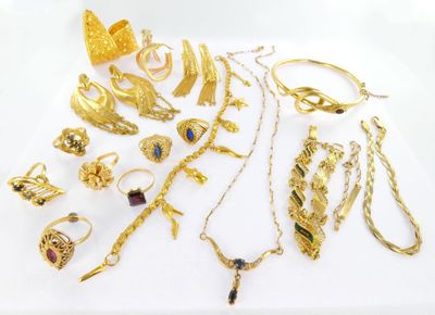 a lot of gold jewelry on a white surface