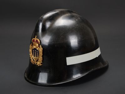 un gros plan d'un casque noir orné d'un insigne doré