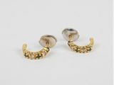 une paire de boucles d'oreilles en or et en argent sur fond blanc