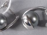 pair of silver earrings with blue stones on a white surface