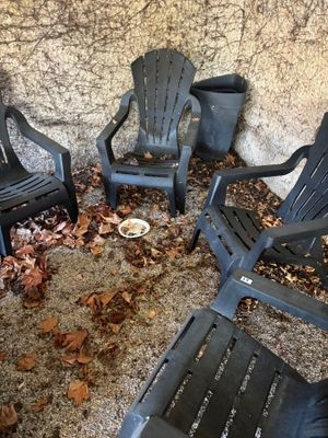 quatre chaises de jardin en plastique disposées en cercle par terre