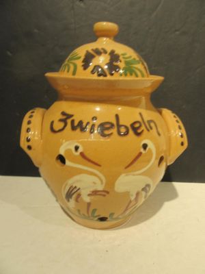 a yellow vase with a lid on a white table