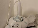 a white teapot on a white table with a clock on top of it