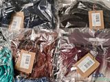 many different colored shirts wrapped in plastic bags on a table