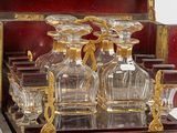 a wooden box with a set of glass decanters on it