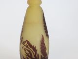 a small yellow vase with a brown design on it