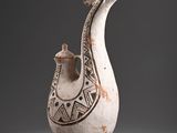 a white vase with a design on it on a gray surface