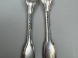 two forks that are sitting next to each other on a table