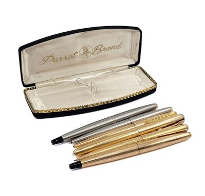 two pens and a pen in a case on a white surface