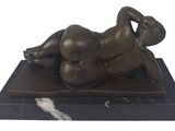 statue of a woman laying down on a marble base