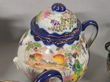 three cups and a teapot sitting on a table