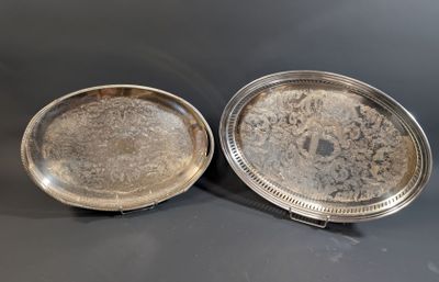 two silver trays sitting on top of a table next to each other