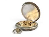a silver pocket watch that is open on a white surface