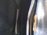 the inside of a black purse with a gold zipper