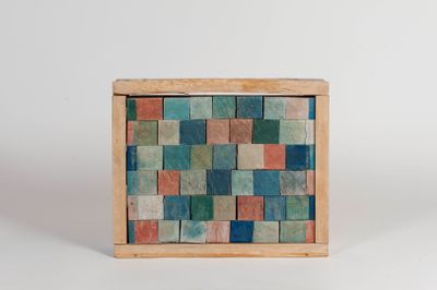 a small wooden box with a multicolored tile pattern on it