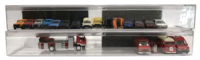 de nombreuses petites voitures dans une vitrine posée sur une surface blanche