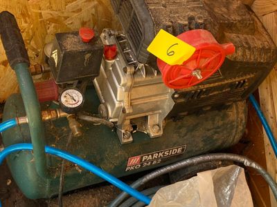 a green air compressor sitting on top of a wooden box