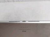 the back of a silver laptop computer sitting on top of a white table