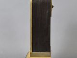 a clock that is sitting on a stand on a gray surface