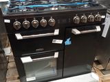 une photo d'un four de cuisine noir posé sur une palette
