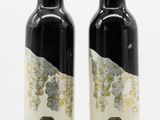 two bottles of olive oil sitting next to each other on a white surface
